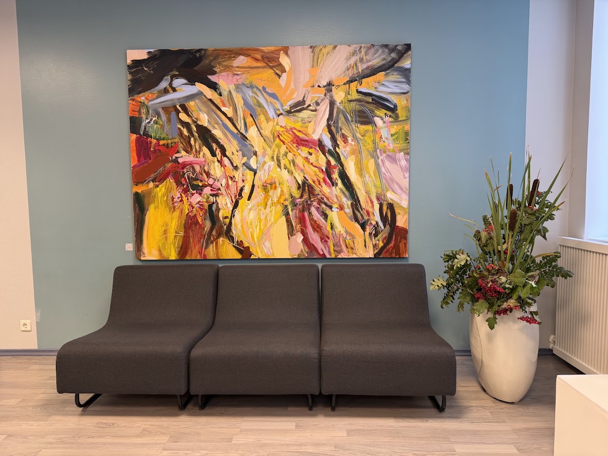 Large colorful abstract painting in contemporary office lounge with grey seating