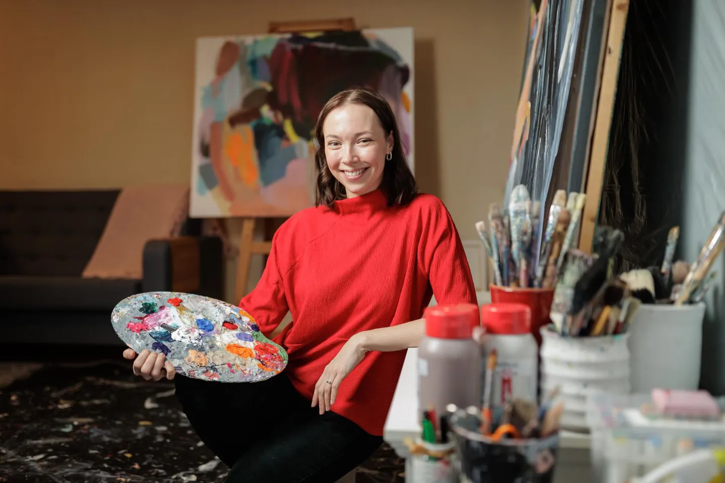 Liisa Jugapuu ateljeessaan paletti kädessään