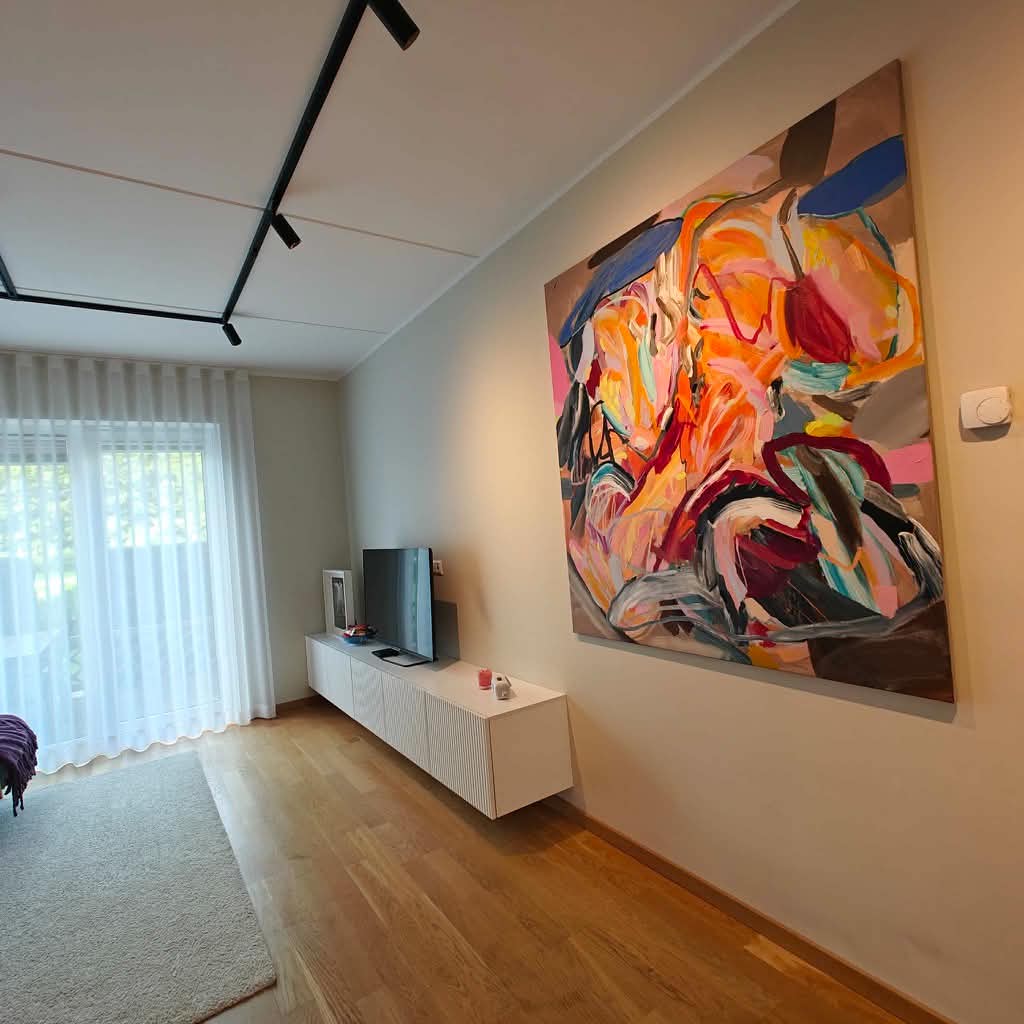 Large colorful abstract painting on living room wall above white sideboard