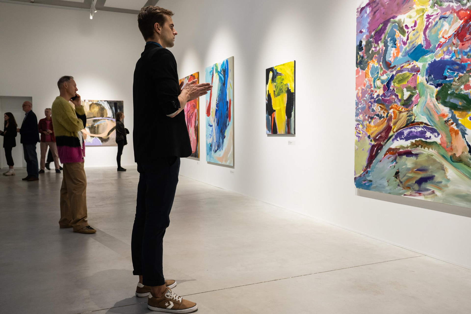 Visitors viewing paintings at gallery exhibition