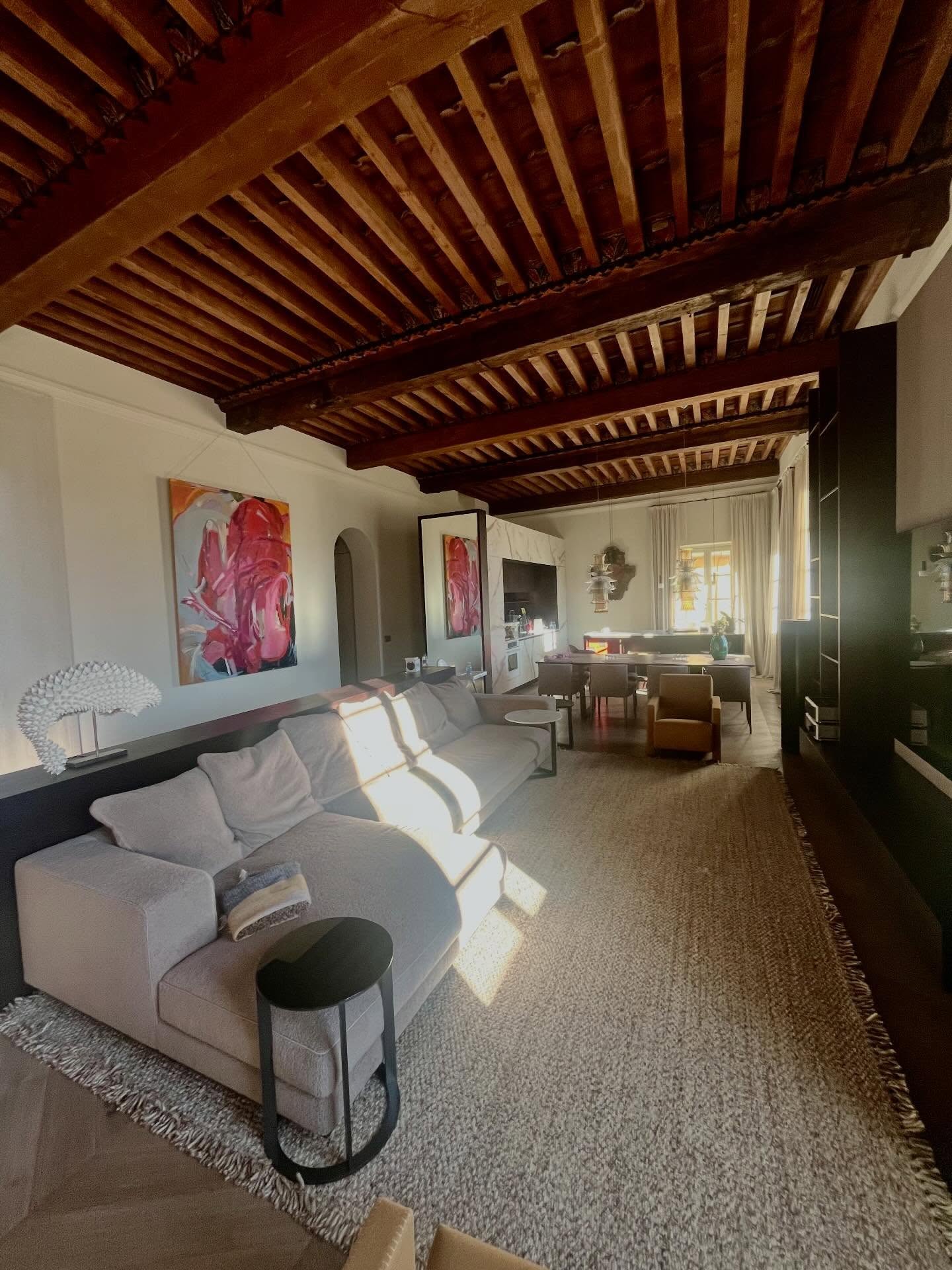 Pink abstract painting in living room with wooden beam ceiling