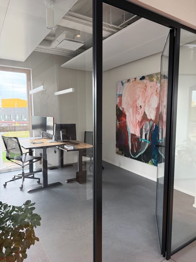 Large pink and teal abstract painting in modern office interior