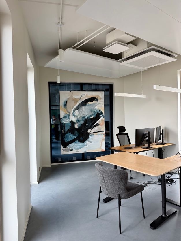 Black and blue abstract painting in bright office interior
